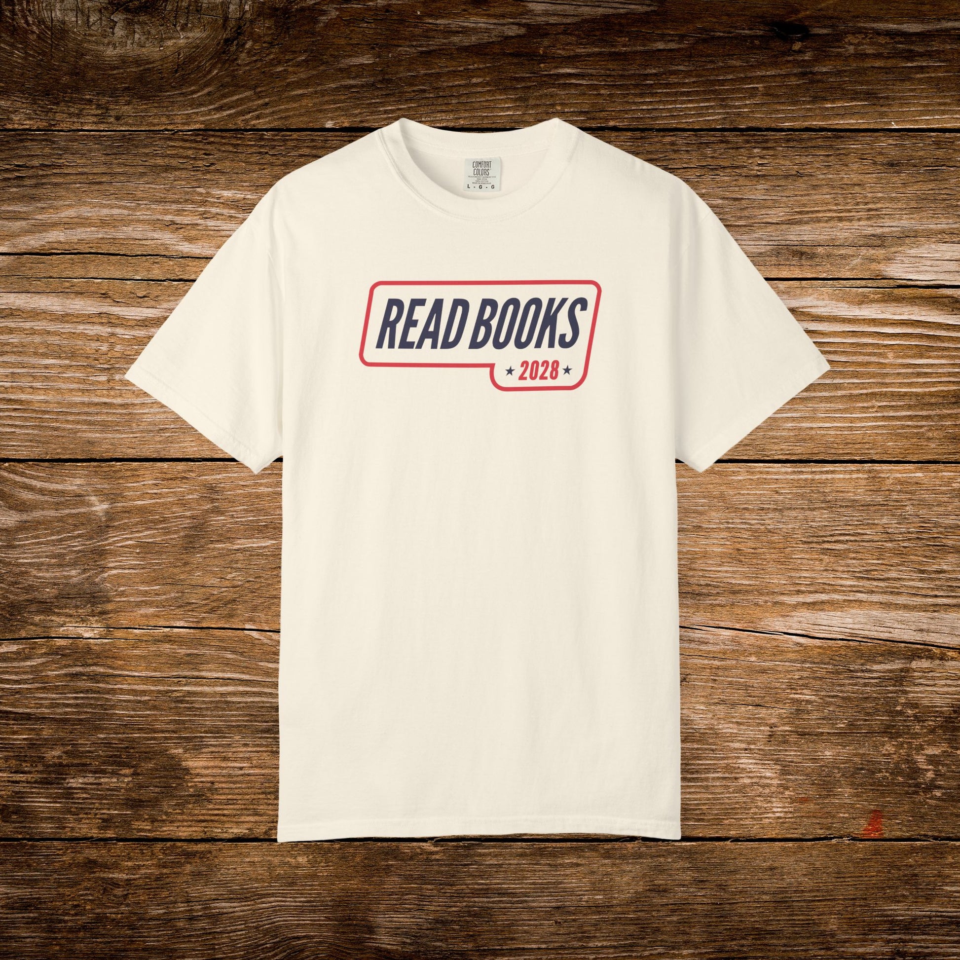 5. Flat Lay
    Ivory Read Books 2028 graphic t-shirt on a wooden background.