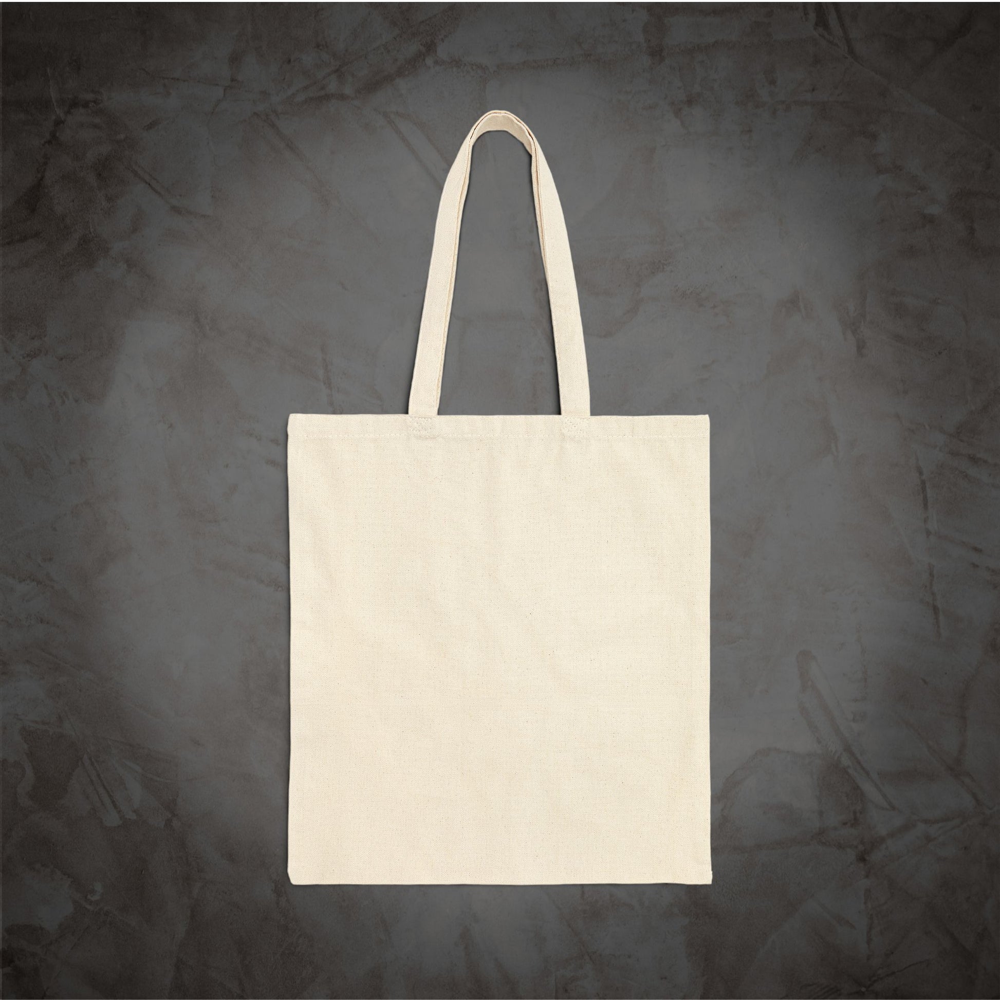A blank off-white canvas tote bag with two shoulder straps, centered against a dark textured gray background.