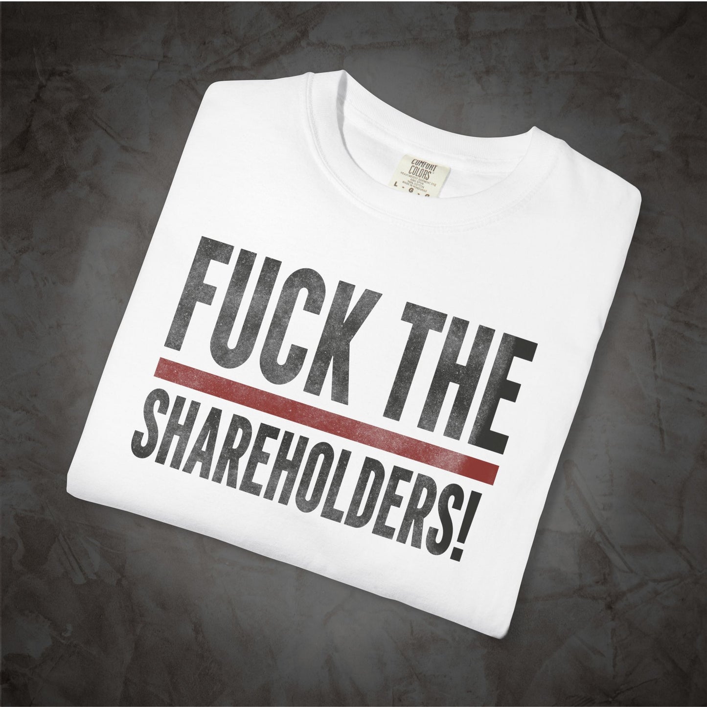 A white crewneck t-shirt with the text 'FUCK THE SHAREHOLDERS!' printed in black, separated by a thick red horizontal line, displayed on a dark textured background.