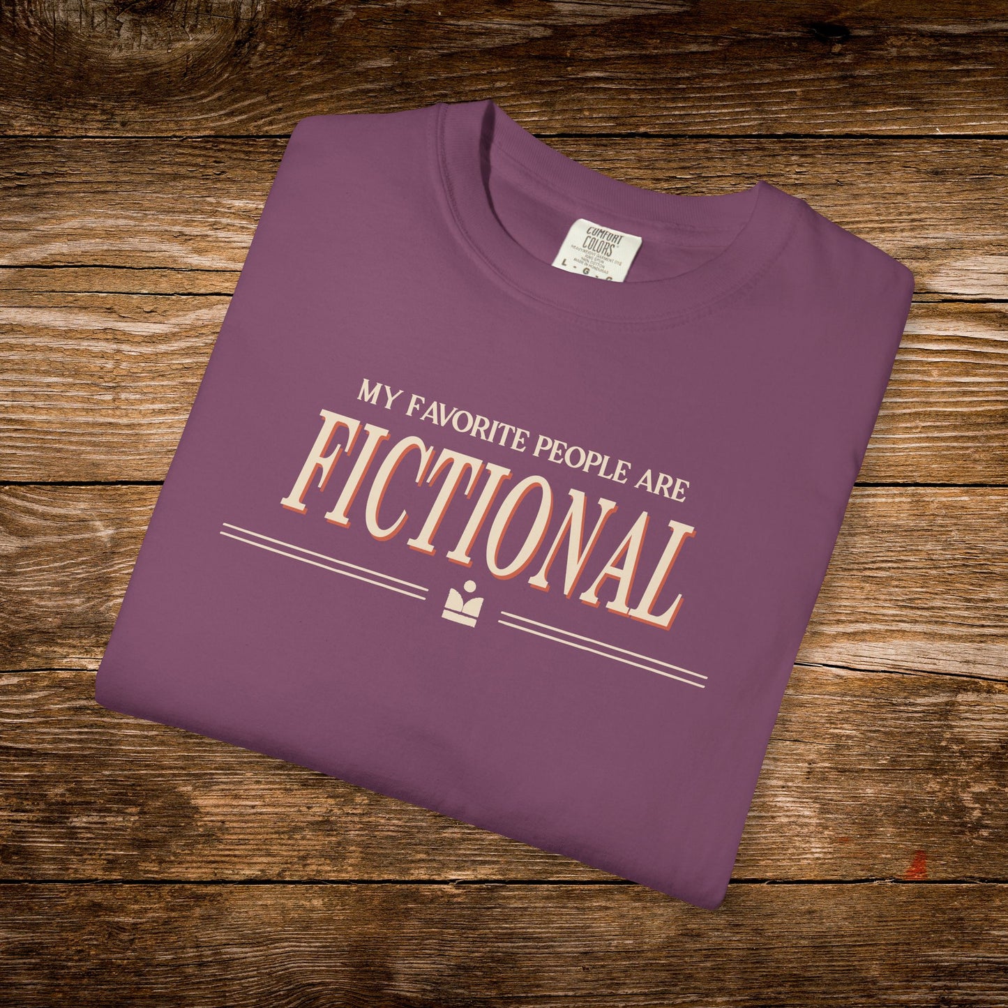 Folded purple t-shirt with text on a wooden surface
