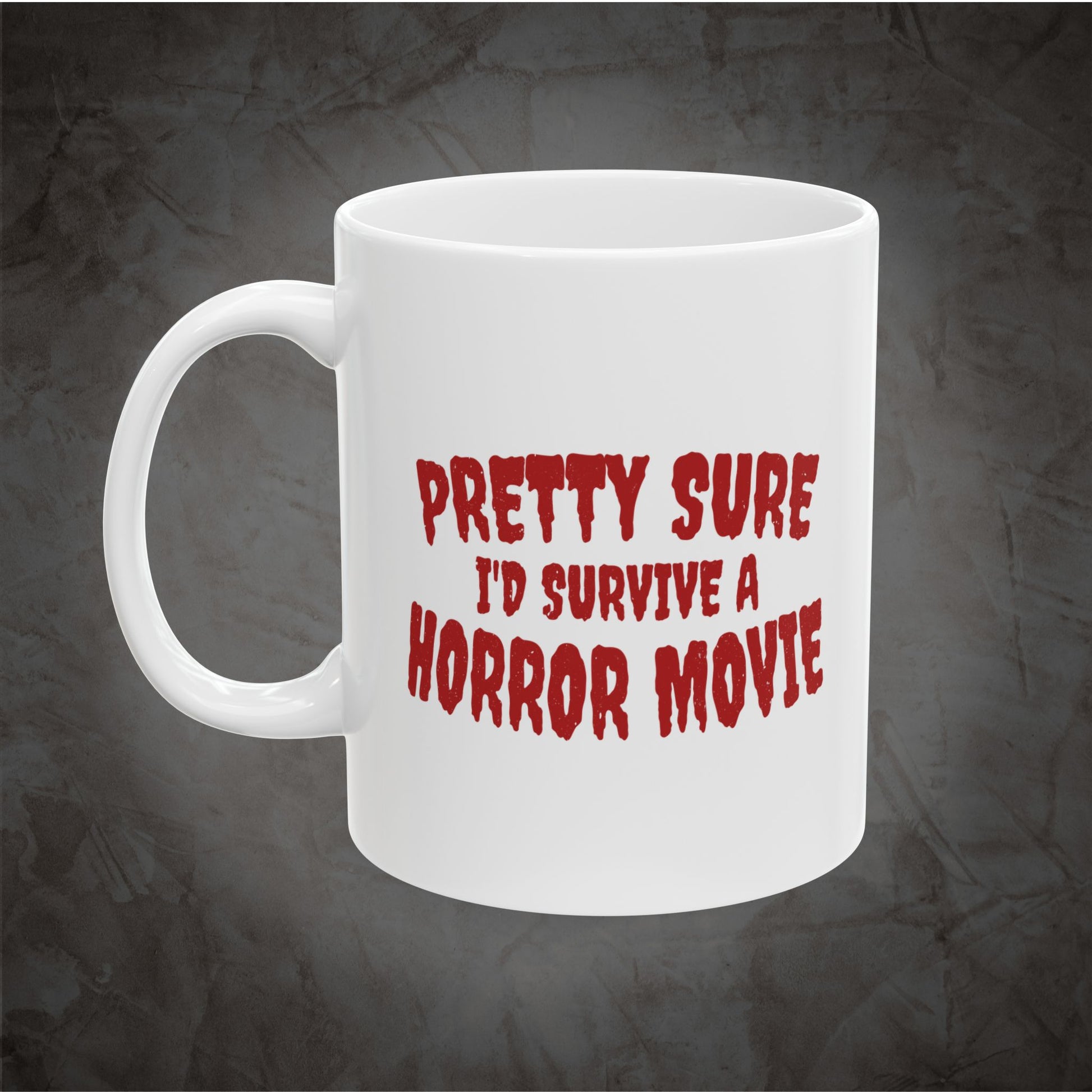 A white ceramic coffee mug with the phrase 'PRETTY SURE I'D SURVIVE A HORROR MOVIE' printed in a red, distressed horror-style font, set against a dark textured gray background.
