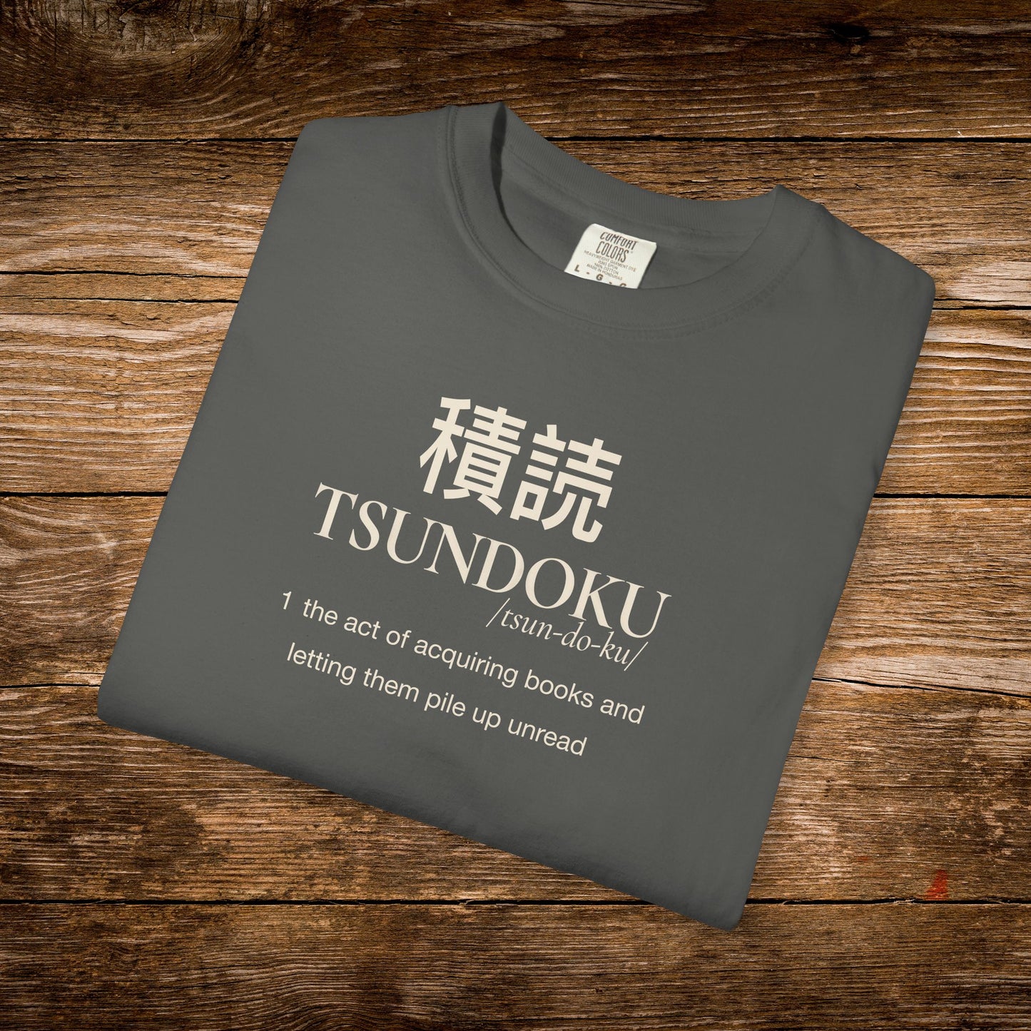 Folded pepper Comfort Colors T-shirt featuring the Tsundoku dictionary definition design.