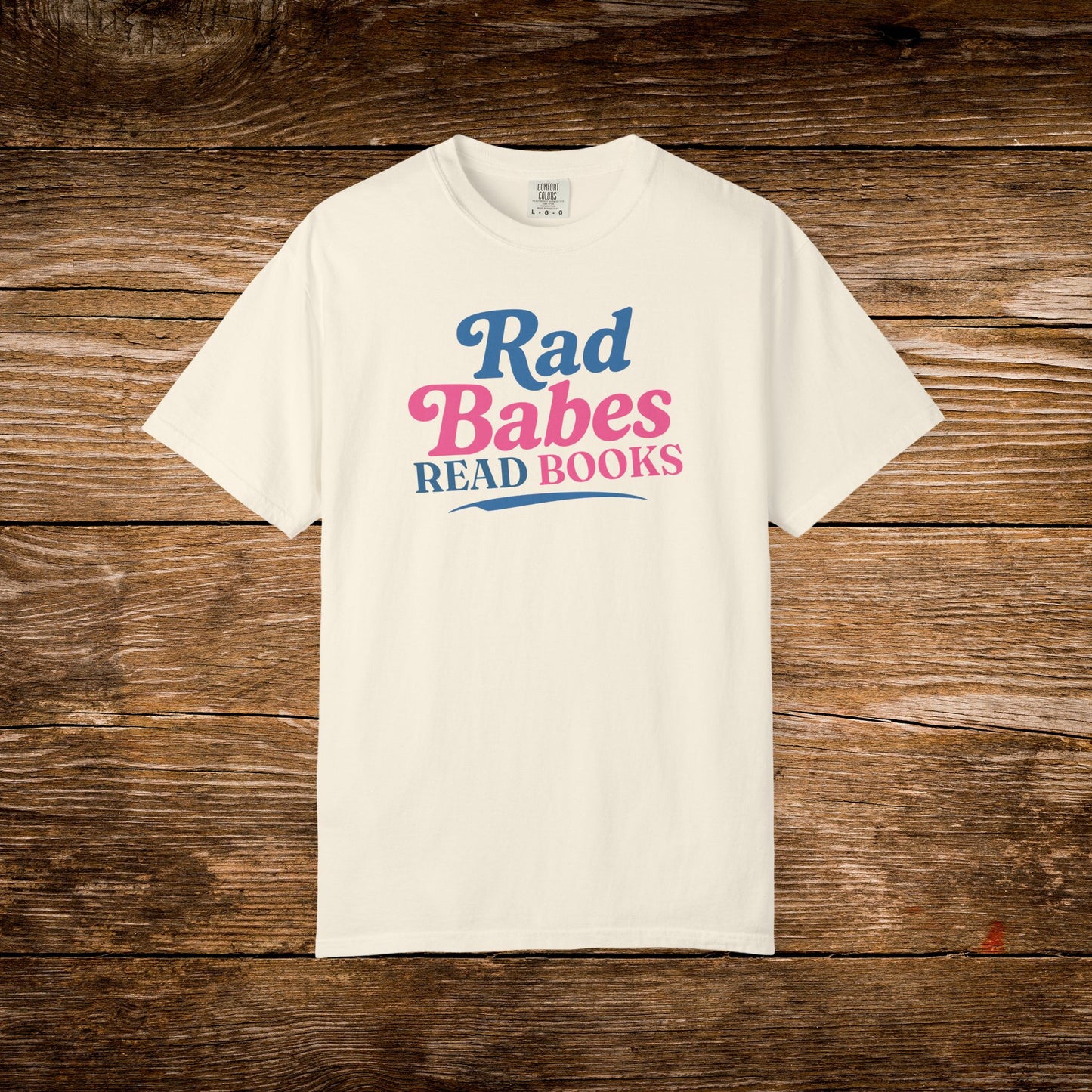 4. Front View
    Ivory Rad Babes Read Books graphic t-shirt on a wooden background.