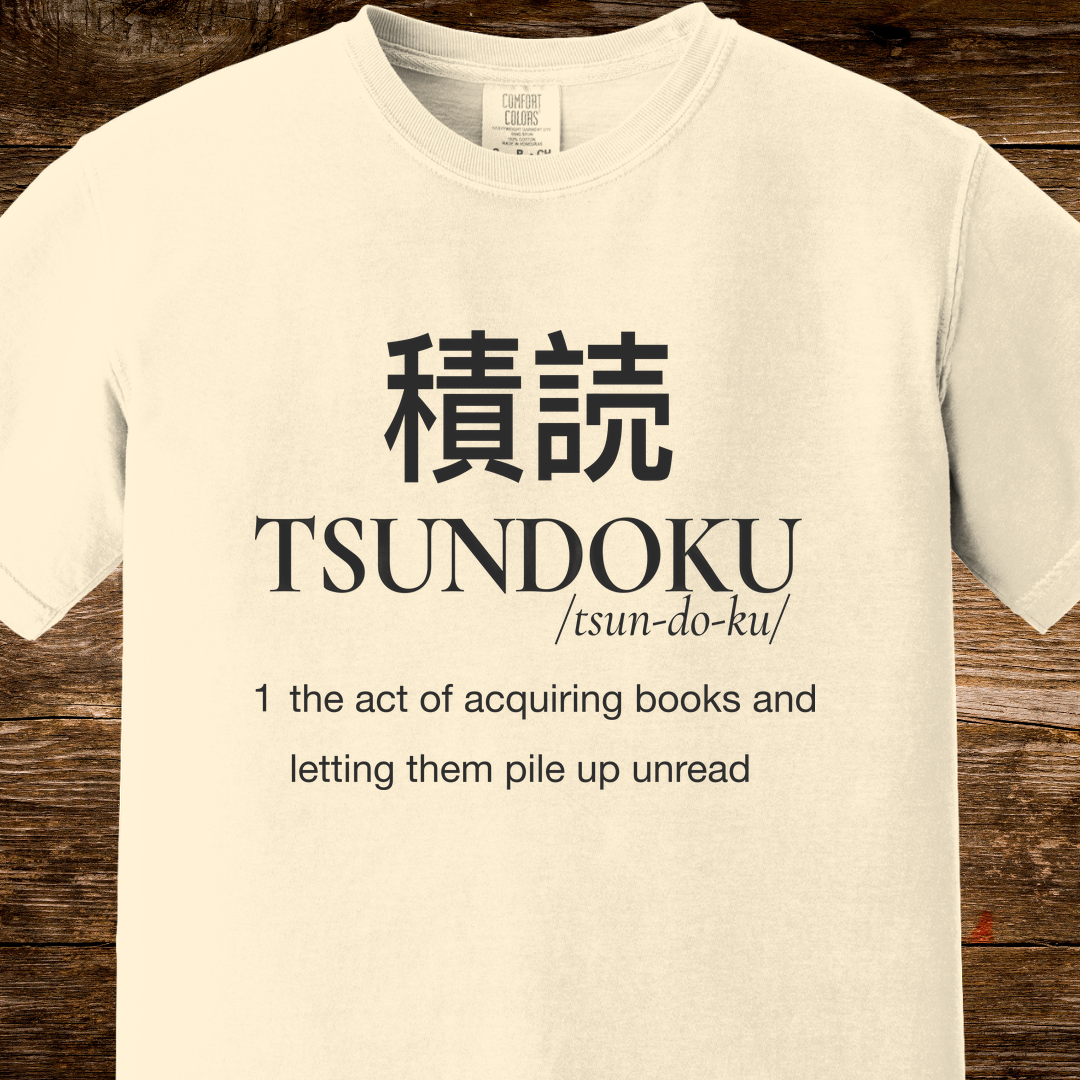 Tsundoku dictionary definition printed on an ivory Comfort Colors T-shirt with minimalist vintage typography.
