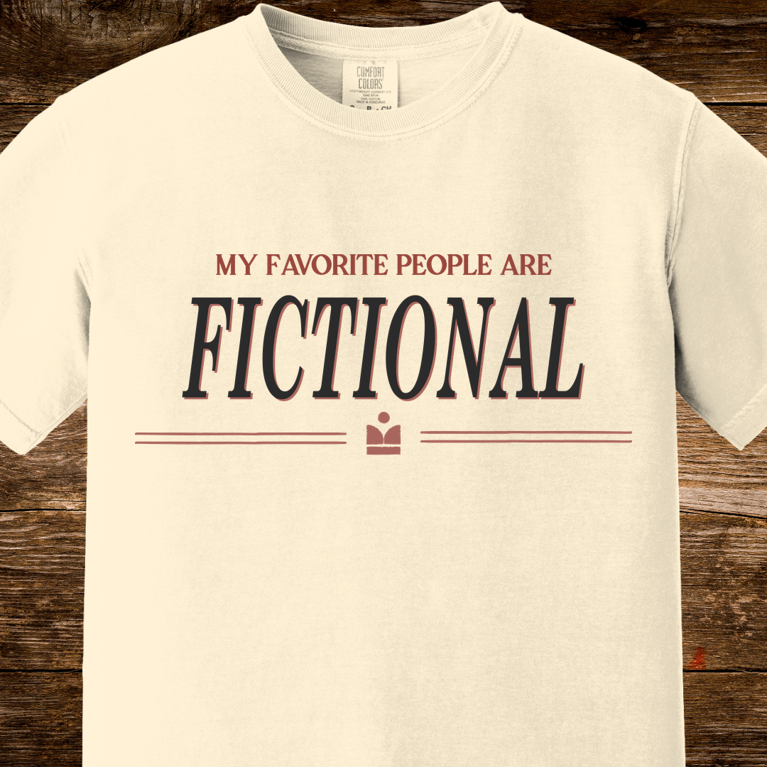 Beige t-shirt with 'My Favorite People Are Fictional' text on a wooden surface