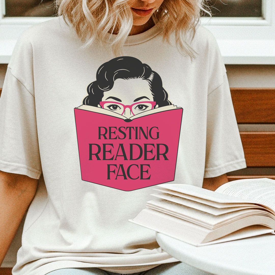 Woman reading a book while wearing the Resting Reader Face graphic t-shirt.