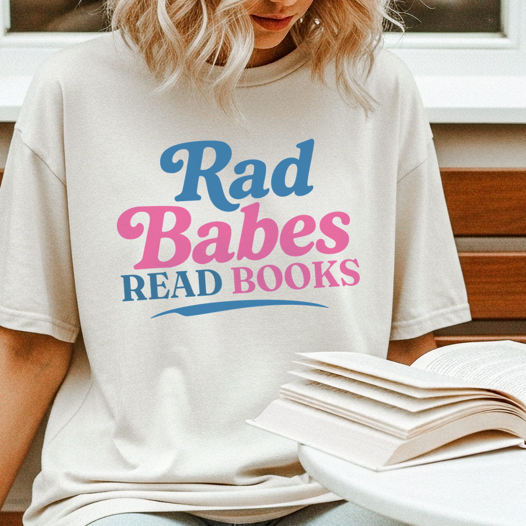 3. Lifestyle Mockup
    Woman reading while wearing the Rad Babes Read Books vintage reader t-shirt.