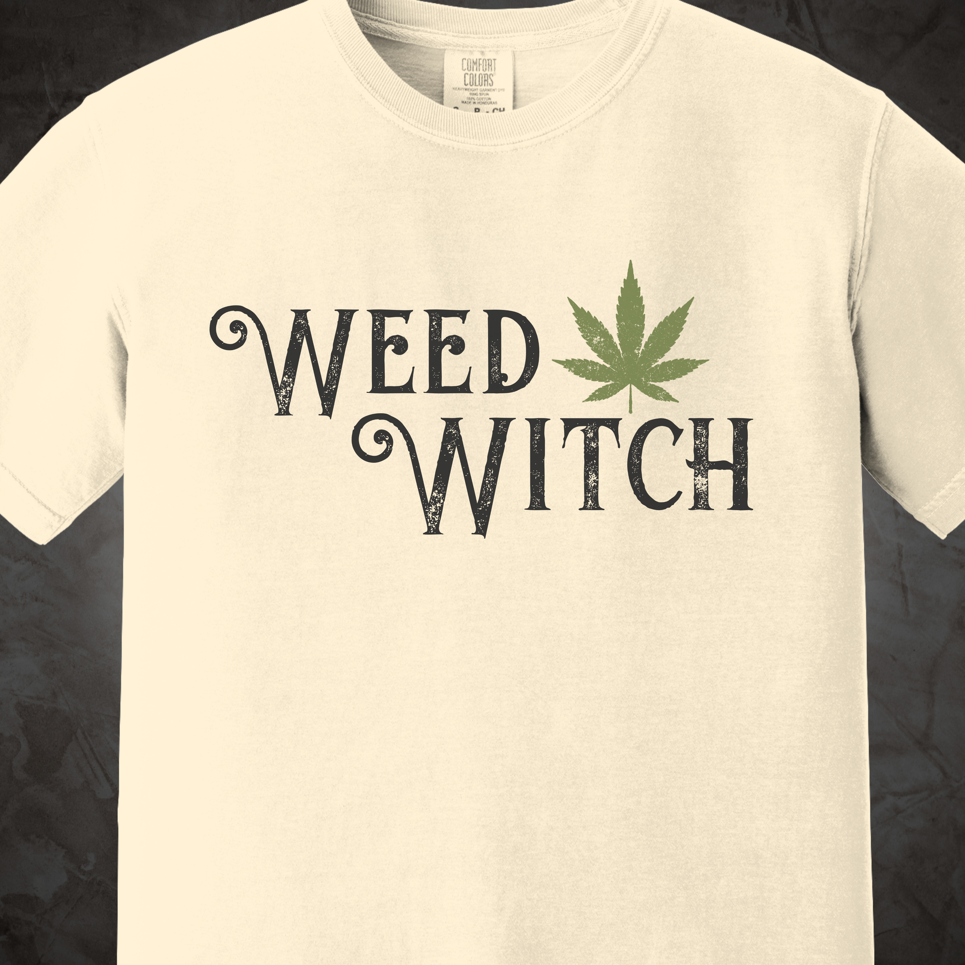 Off-white Weed Witch graphic T-shirt with distressed black lettering and a green cannabis leaf.