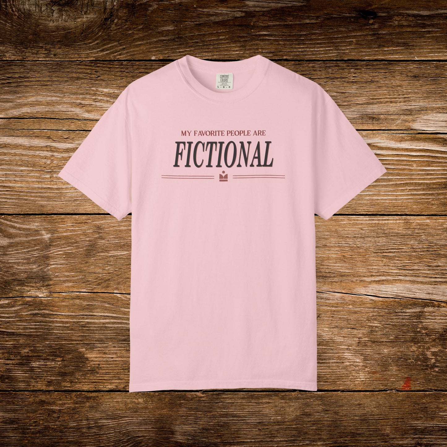 Pink t-shirt with text on a wooden surface