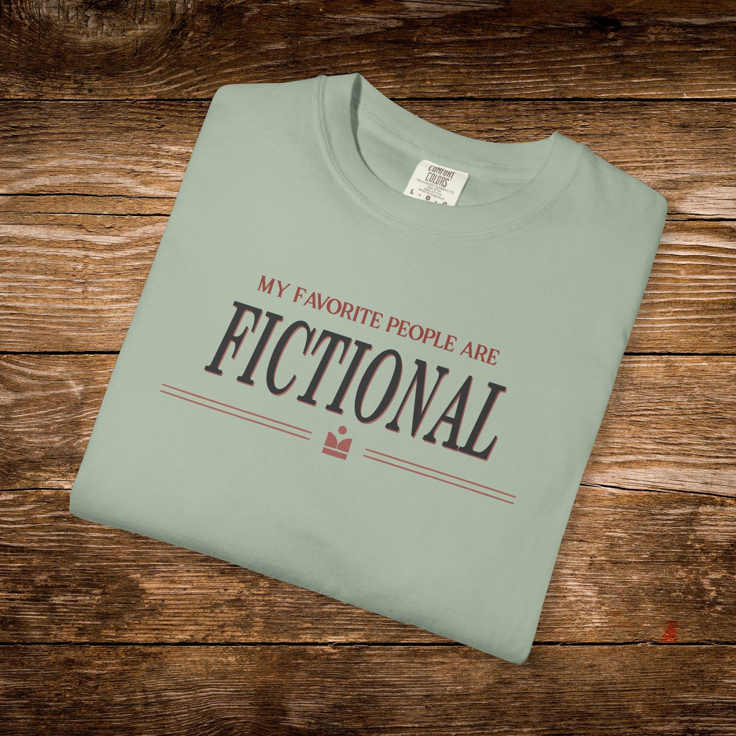 Folded green t-shirt with text on a wooden surface