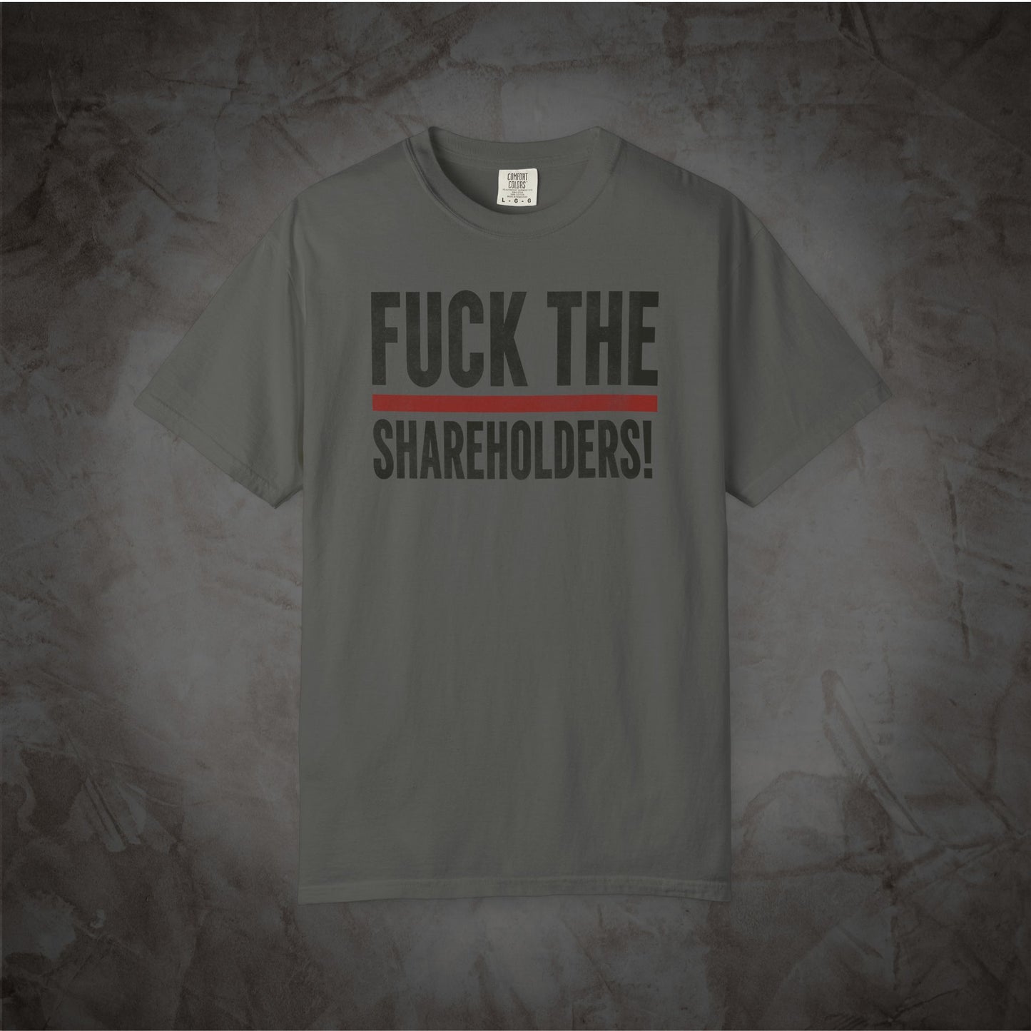 A dark gray crewneck t-shirt with the text 'FUCK THE SHAREHOLDERS!' printed in black across the chest, separated by a single red horizontal line, displayed against a textured gray background.