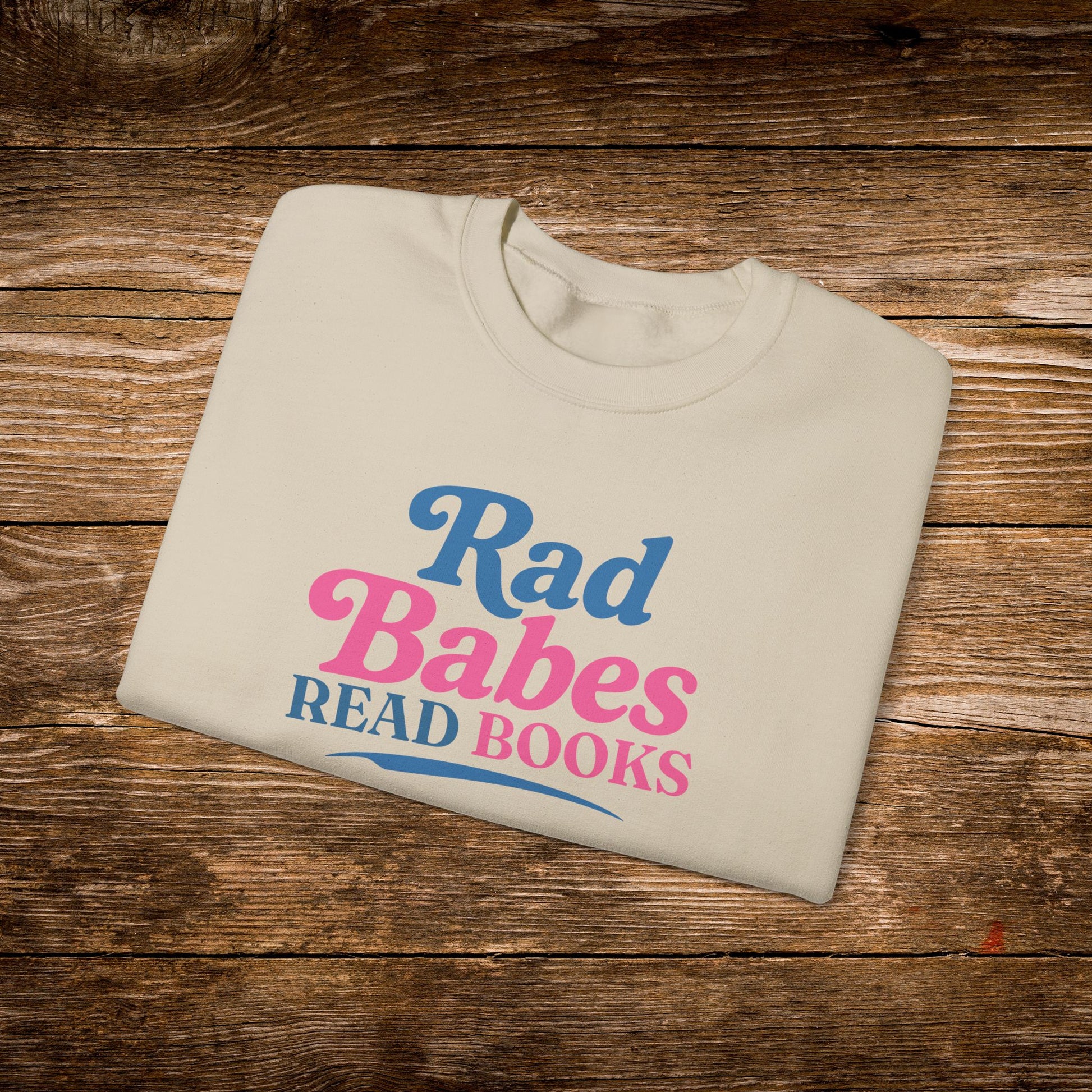 4. Folded Flat Lay
    Folded sand Rad Babes Read Books graphic sweatshirt.