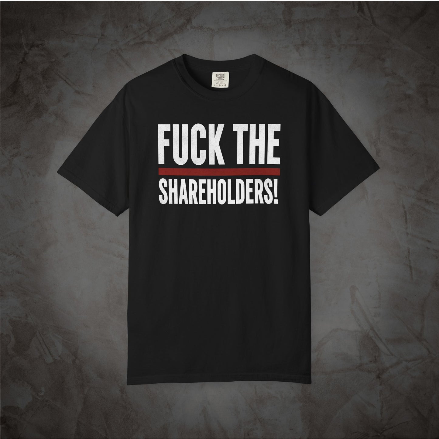 A black short-sleeve t-shirt with the text 'FUCK THE SHAREHOLDERS!' printed in white across the chest, separated by a thin red horizontal line, displayed against a textured gray background.
