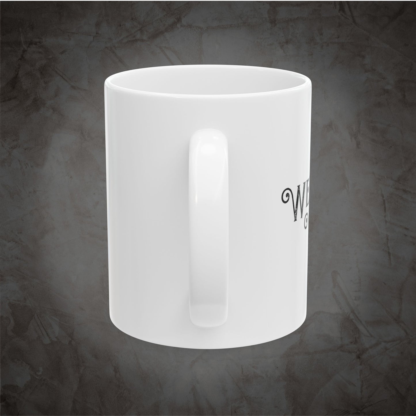 A white ceramic coffee mug with a handle, featuring partial black text on the side, set against a textured dark gray background.