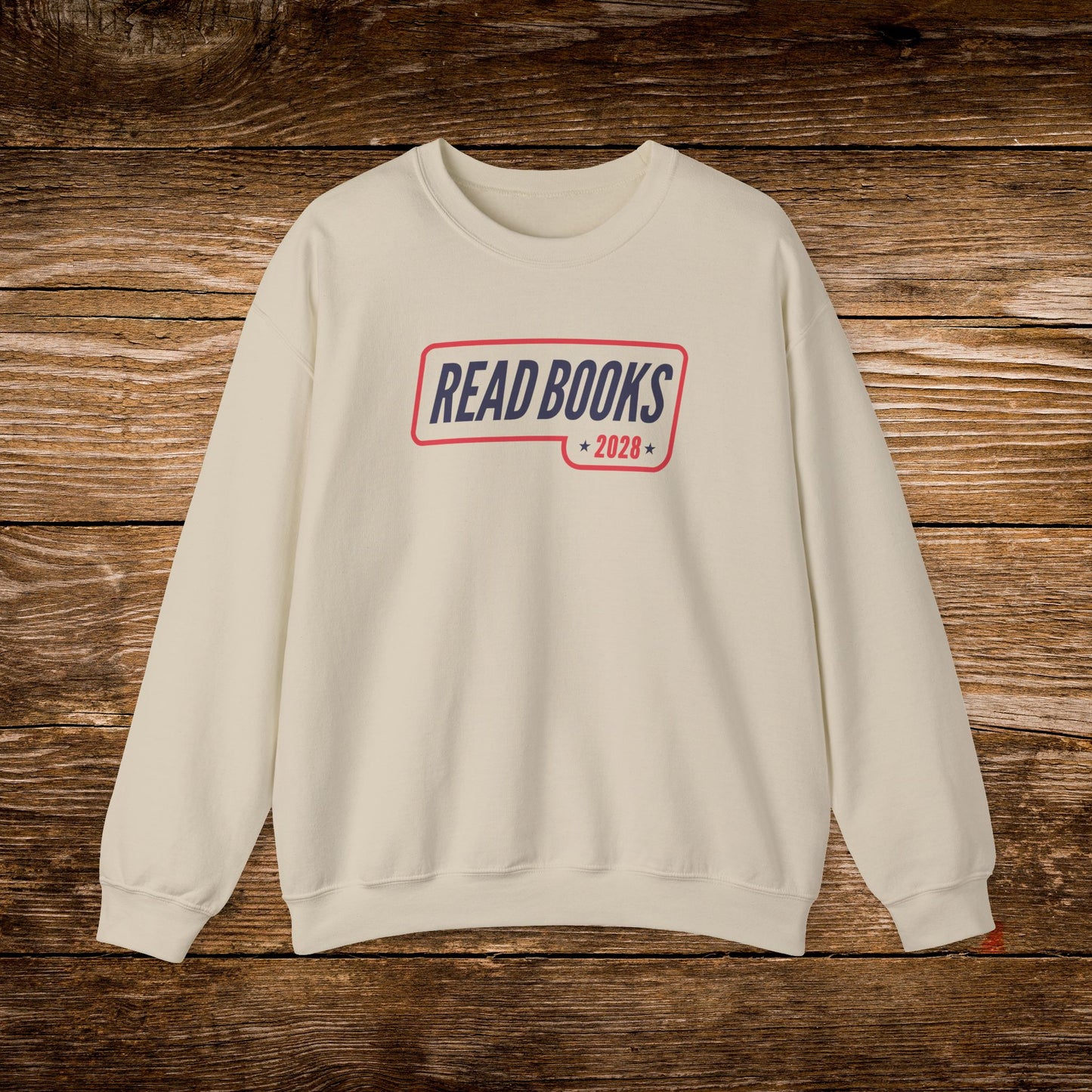 4. Front View
    Sand Read Books 2028 graphic sweatshirt on a wooden background.