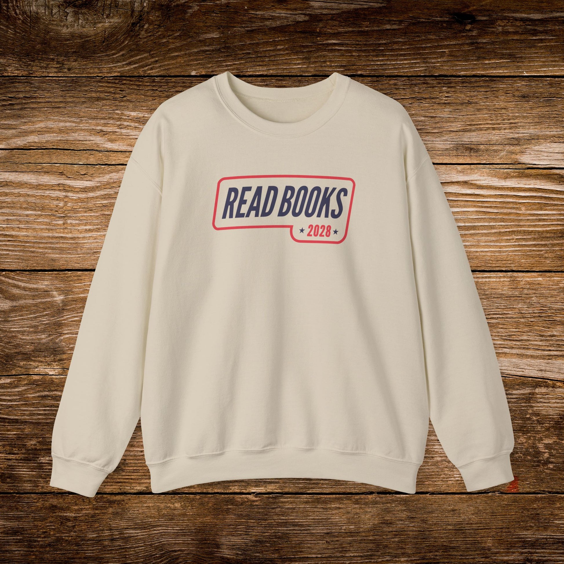 4. Front View
    Sand Read Books 2028 graphic sweatshirt on a wooden background.